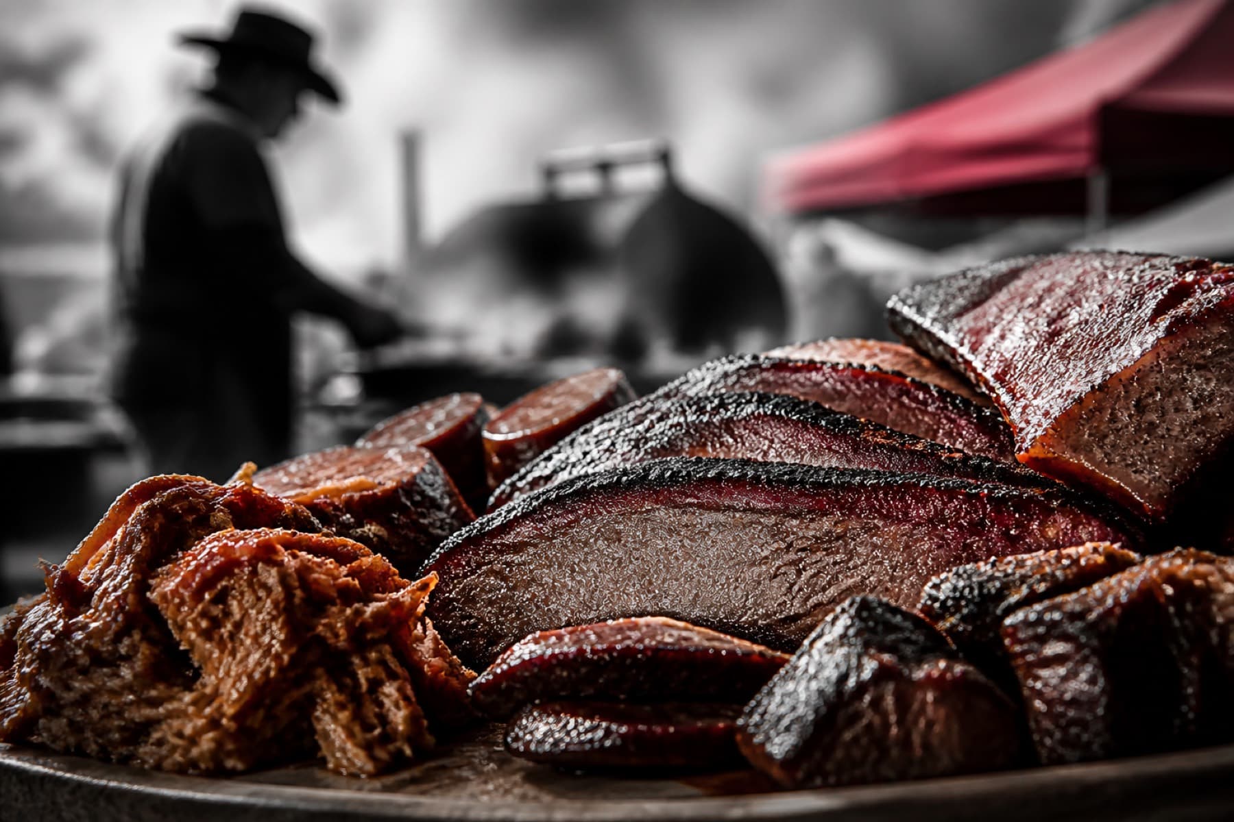 Charred grilled meat platter with smoke at an outdoor BBQ tasting