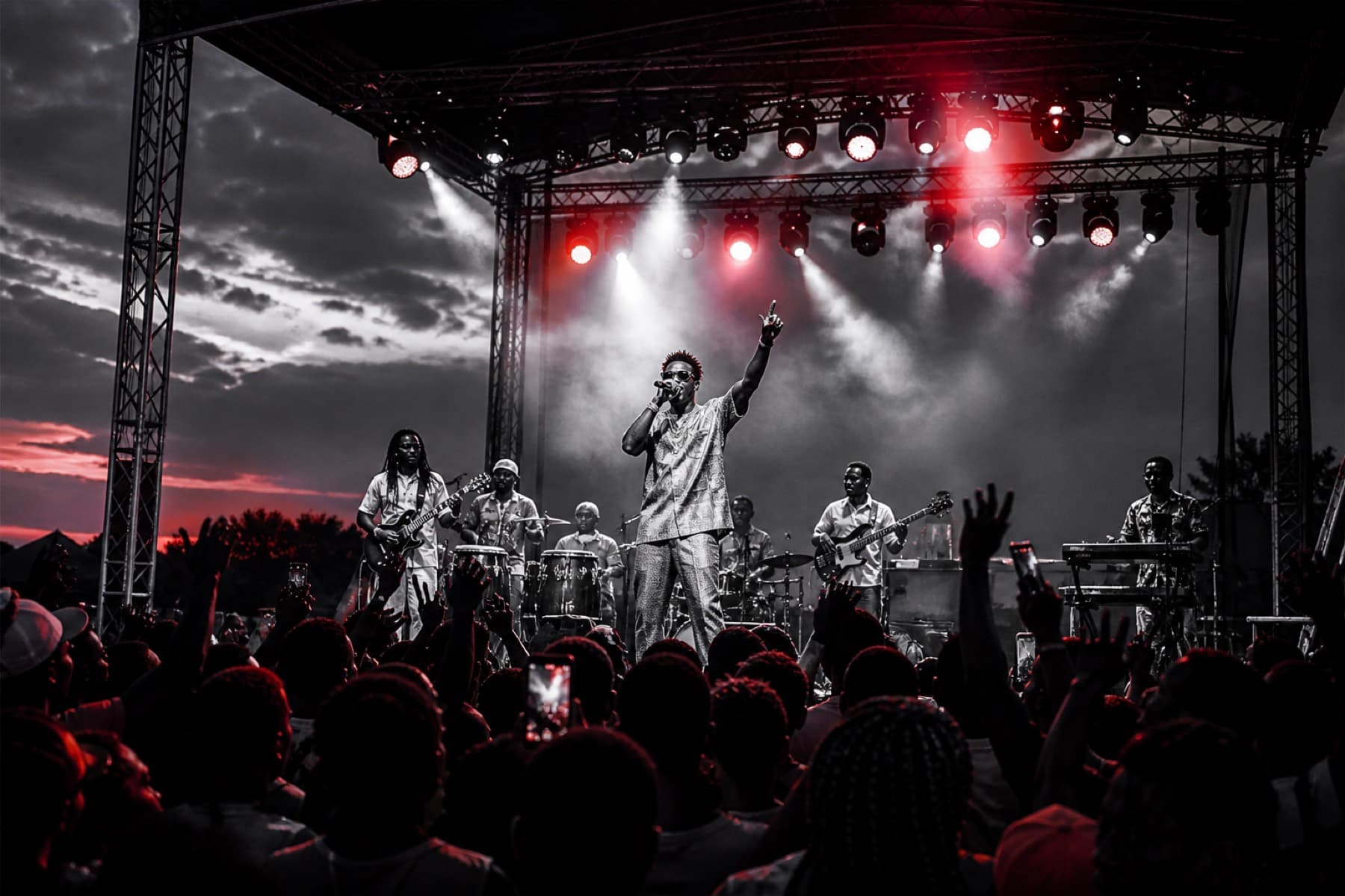 Live Afrobeats band performing on an outdoor festival stage at dusk